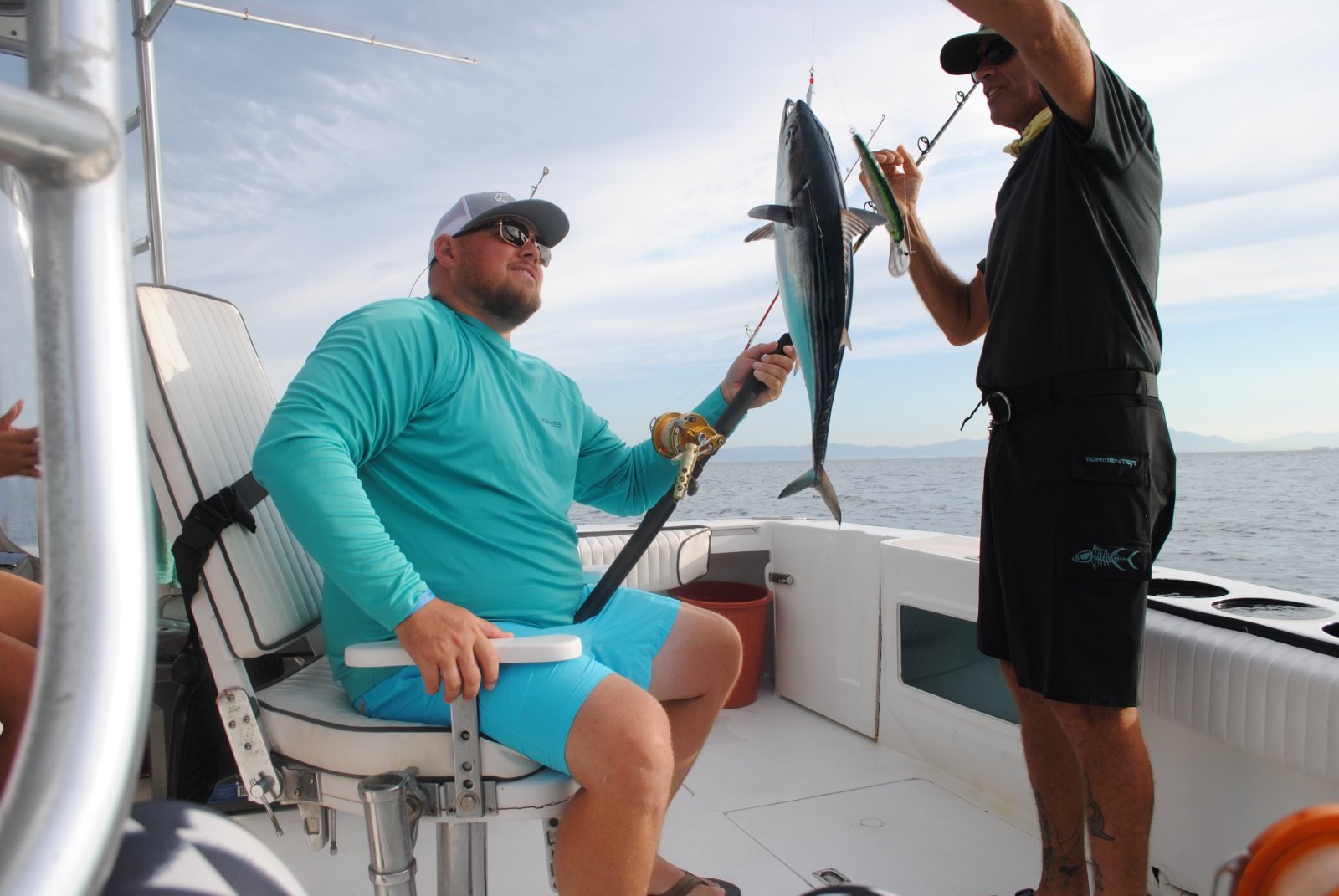Our mate unhooking a fish for a guest in the fighting chair