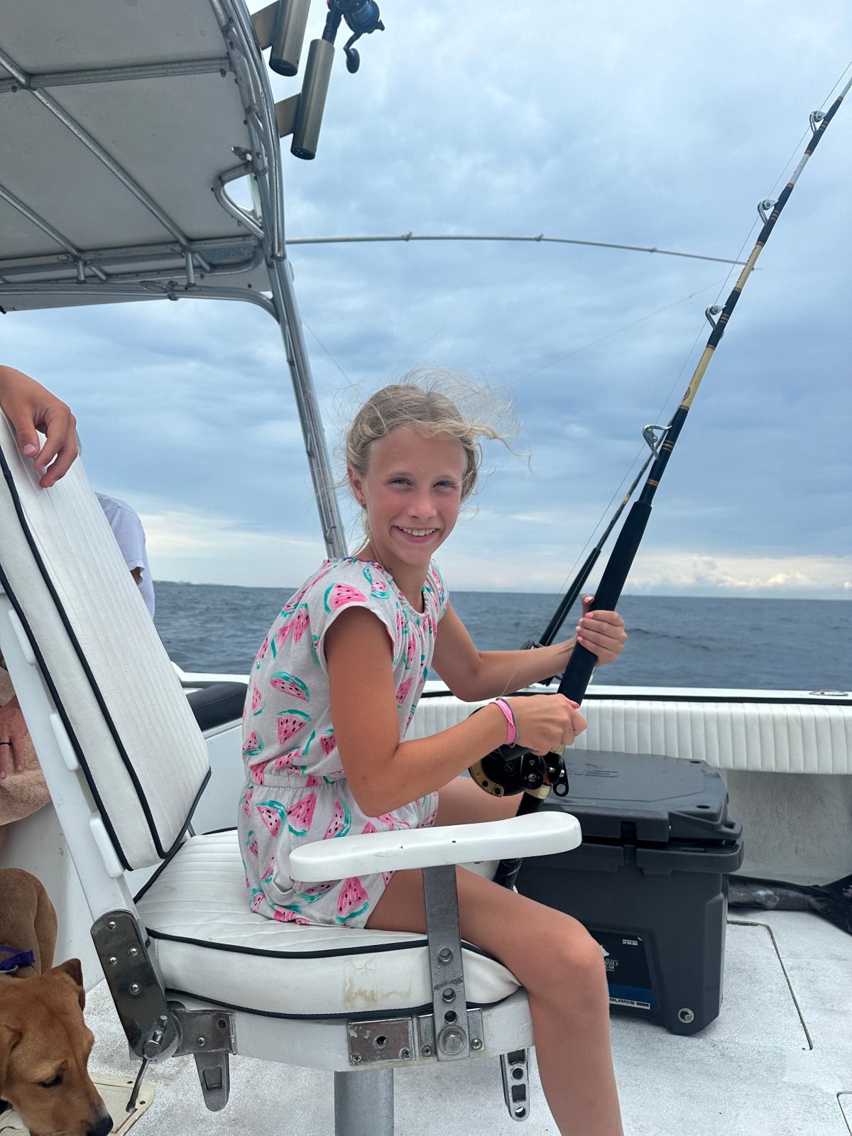 A young angler working a rod from the fighting chair on a family fishing charter in Banderas Bay